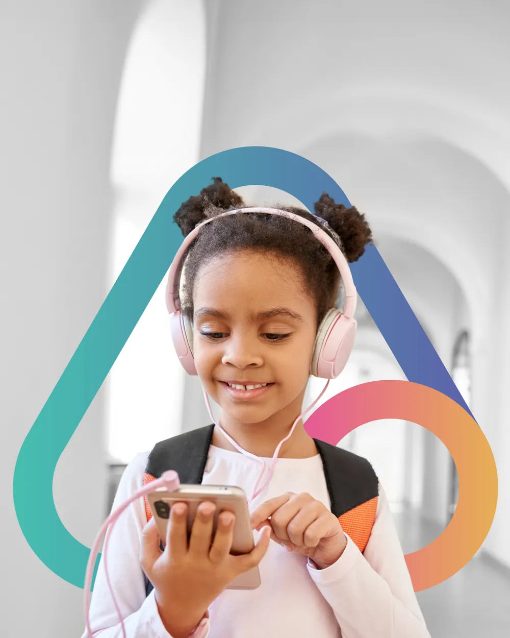 A young schoolgirl with headphones using a smartphone